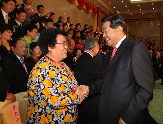图文-贾庆林会见出席开幕式华侨代表 两人热情握手
