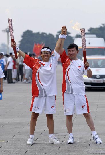 图文-奥运圣火北京首日传递 马一德与陈麒亦交接火炬