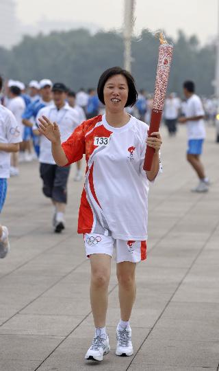 图文-奥运圣火在北京进行首日传递 温桂华亲切招手
