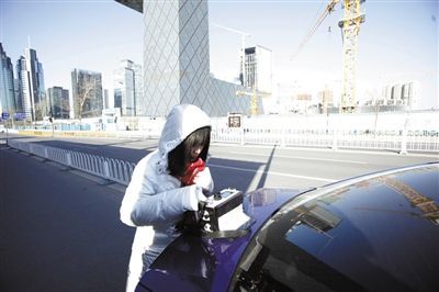 12月10日，环保志愿者在国贸附近检测PM2.5的数值。本报记者 王嘉宁 摄 