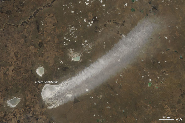 照片展示了哈萨克斯坦北部草原湖泊附近扬起的细泥沙尘柱。