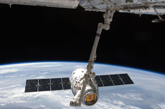 SpaceX公司的龙飞船正逐渐接近国际空间站，以便空间站上的机械臂可以将其捕获并转移至相应的对接平台