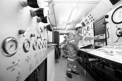 　　工作人员在“深潜号”上的潜水控制舱里调试设备。