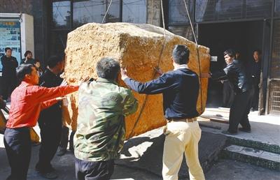 广西出土巨棺渗漏不明液体 11月29日,工人将"三合土"巨棺吊起运进