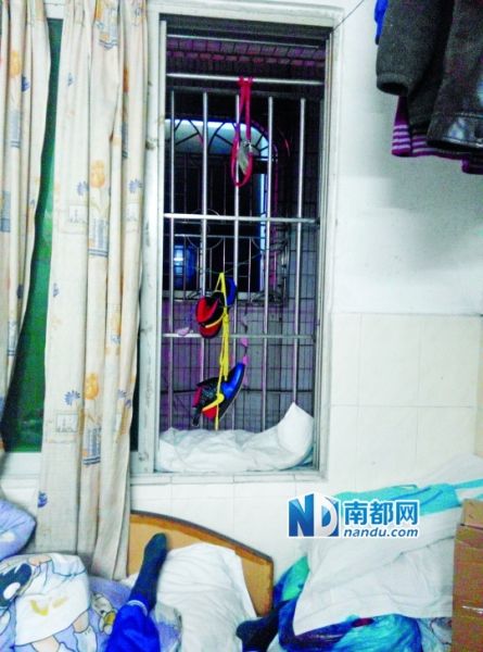  孩子被奶奶发现时，脖子挂在红色胸卡绳上。胸卡绳的另一头拴在窗口防盗网上。家属供图