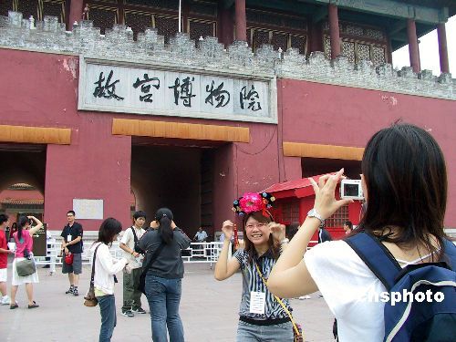 资料图:2005年7月13日,参加第五届“湖湘文化之旅”、来自台湾36所大学的100余名台湾青年学子,在北京故宫博物院参观。图为一台湾女生在故宫神武门前戴起宫廷帽拍照留念。 资料图:2005年7月13日,参加第五届“湖湘文化之旅”、来自台湾36所大学的100余名台湾青年学子,在北京故宫博物院参观。图为一台湾女生在故宫神武门前戴起宫廷帽拍照留念。
