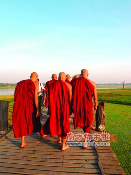一群僧人走上古老的乌本桥。 一群僧人走上古老的乌本桥。