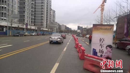 3月8日，柳州万达广场行促销宣传活动现场，附近道路被房开商用路障圈占用作停车场，延绵一公里长。蒙鸣明摄