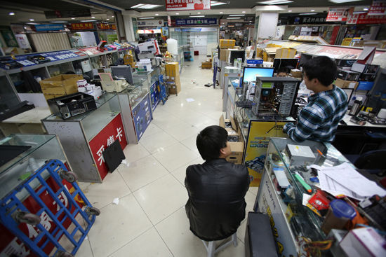 1月22日，北京中关村e世界电子市场一楼已经没有商铺，二至四层的店铺还在营业，有的已经陆续撤离，只有一两名顾客前来购买电子产品。CFP供图