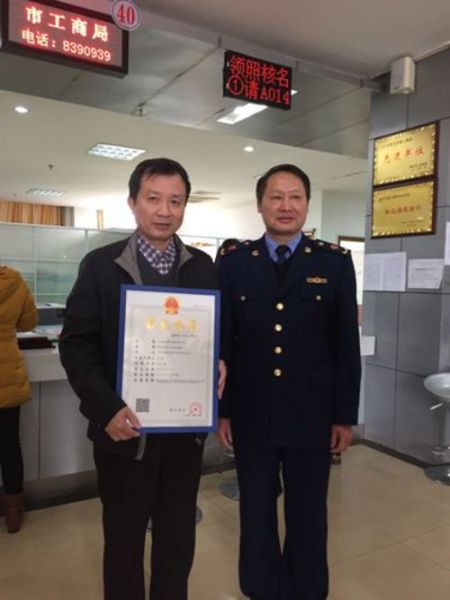 　　赣州市工商局长向中国南方稀土集团董事长黄光惠颁发营业执照(左一为黄光惠) 于垚峰 摄