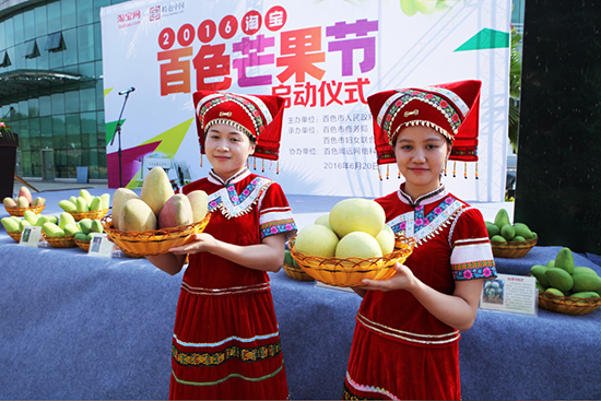 身穿民族服装的少女在展示百色芒果 2016百色芒果节正式启动