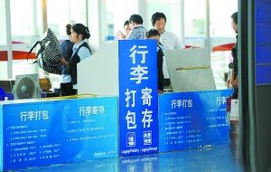 在江西南昌昌北机场，工作人员在给旅客提供打包服务。一个纸箱子40元、一根包装带15元、缠几圈保护膜20元…… 周科摄 