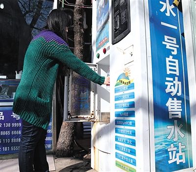 去年3月，在朝阳一小区内，市民在净水机前接水。据统计，目前北京有4万台类似的净水机。 新京报资料图片 王远征 摄