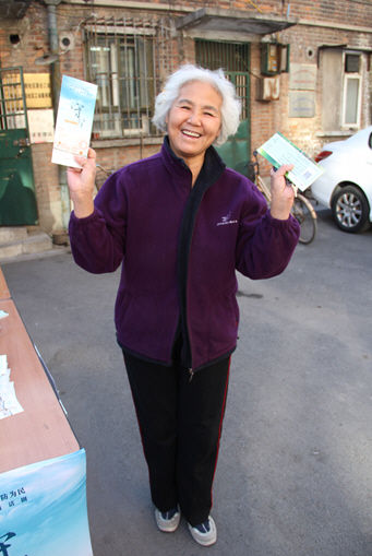 得到话剧票的老人非常开心地展示了手中的票 北京民防局首尝创新模式 公益话剧进高校社区