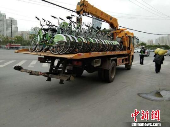 图为兰州交警部门采用拖车将随意停放的共享单车统一收集拖离。 兰州将划共享单车停车区和禁停区 暂不投放新车