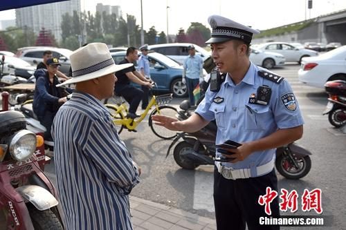 6月21日上午,北京交警敖翔处理交通违法行为。 北京启动路口“最严执法” 出狠招整治交通乱象