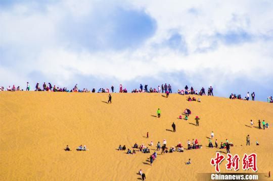 资料图:2017年“五一”小长假期间,游客登上甘肃敦煌鸣沙山月牙泉观赏大漠风光。 王斌银 摄 甘肃旅游业谋转型升级 兼蓄各方人才打造“智囊团”