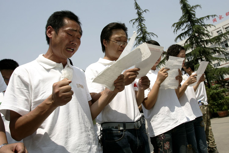 图文:教师在绵竹中学破损校舍前为遇难者哀悼