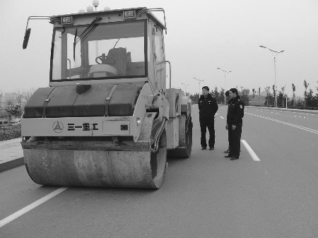 开着压路机驶上滨河路