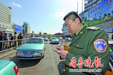 4月28日,济南火车站出租车等客区,稽查人员对出租车进行现场监督.