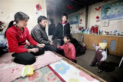 李瑞（右二）一家五口人挤在一间屋子里，为了给孩子治病，家中已没有什么像样的东西摄/记者 王丹