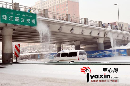 12月28日，珠江路立交桥上几位环卫工正将桥上的积雪仍到桥下的河滩快速路上。亚心网记者 李远新 摄 