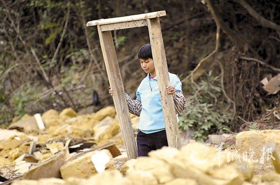 村民把一个门框从废墟中找出来，这曾经是她家的家门
