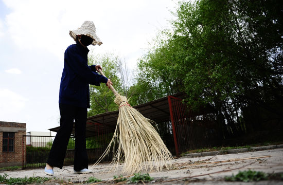 5月17日，中国铝业青海分公司职工罗静源在公司内清扫垃圾。  新华社记者张宏祥摄 