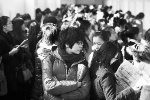今年3月2日，北京举办的一次“女生招聘会”上，一位女生在寻找合适的职位。本报记者 浦峰 摄