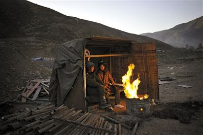昨日19时许,援建工人在玉树重建的工地旁烧火取暖.本报记者 李强 摄