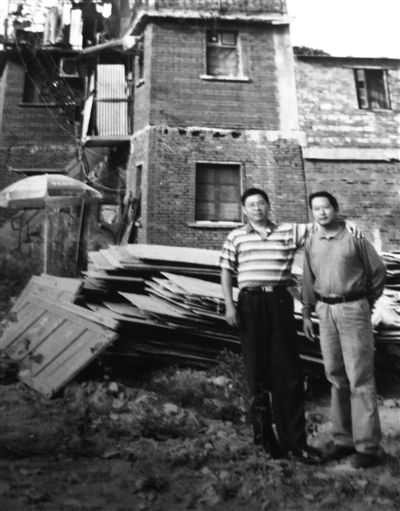 2009年，张安房（左）和朋友在老屋前合影，他家已被停水断电一年。