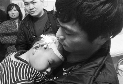 河南永城市马桥镇一名家长抱着孩子在医院治疗。本报记者 孟祥超 摄