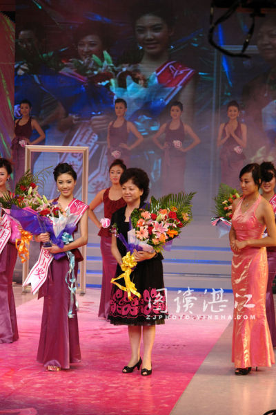 资料图：原湛江市广播电视台台长童小玲(黑衣者)在湛江市广告模特电视大赛总决赛上为获奖者颁奖。图片来源：图读湛江