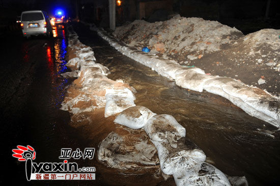 ? 图为,北站三路洪水被引入路边的防洪渠内,居民楼距离防洪渠仅20米。亚心网记者 张梅 摄 ? 当日20时30分,记者赶到现场看到,在北站三路与北站西街交会处,工作人员正忙着修补由沙袋筑成的防洪渠,以防止洪水流入路边的商铺中。 河南庄村三队村民高继生的房子距离渠道只有5米远,地下室的积水足有60厘米深。正忙着用水泵抽水的他告诉记者,下午五六点,他忽然听到地下室传来哗哗的流水声,我一看,一大股水流正从靠渠道的墙壁逢里往外涌,而地上的积水有十几厘米深,可能之前就开始慢慢渗水了。 高继生说