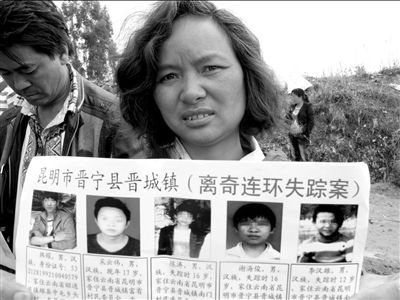 在事发地，陈涛的母亲手举“失踪孩子”的资料。本报记者钱卫华摄