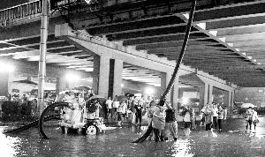 昨天，西三环莲花桥下大量积水，救援人员在紧急排水。晨报记者 史春阳/摄