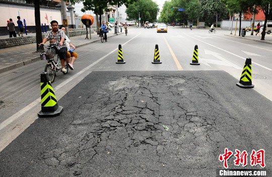 　8月13日，北京市百万庄大街与车公庄南街交叉路口附近出现一处地面塌陷，路政部门及时采取修复措施，未造成严重影响。中新社发 侯宇 摄