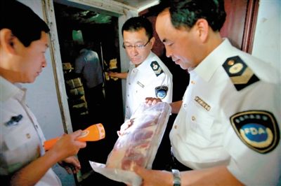 5月8日，山西运城市一名执法人员检查火锅店冷库的冻羊肉。新华社发