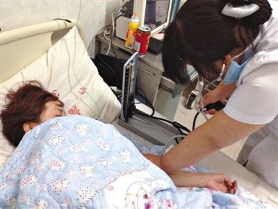5月28日晚，被肇事女司机踢伤的王娟娟在医院接受护士检查。新京报记者 孟祥超 摄