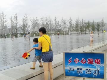 警示牌也挡不住喷泉嬉水的孩子