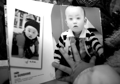 原原的姐姐很想念弟弟，在家一直看弟弟照片。（资料图片）京华时报记者陶冉摄