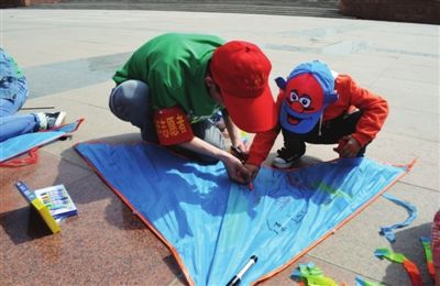 正文   4月1日,在银川市人民广场,志愿者和自闭症孩子一起在风筝上