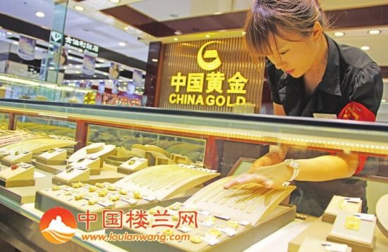 中国黄金金店的店员摆放黄金饰品.