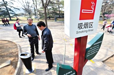 4月1日，两游客在北京动物园吸烟区抽烟。北京动物园水禽湖划分出“吸烟区”，此举为市属公园首次。新京报记者 薛珺 摄