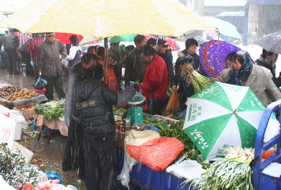 图文:江苏省宜兴市民冒雪在露天菜市场买菜