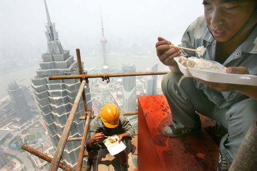 图文:工人蹲在城市最高的490米上空吃盒饭