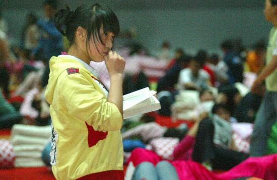 图文:女孩在绵阳市九洲体育馆灾民安置点读书
