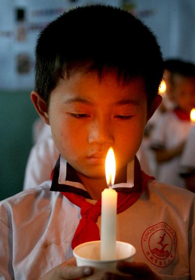 图文:绵阳灾区小学生手托白蜡烛向遇难者哀悼