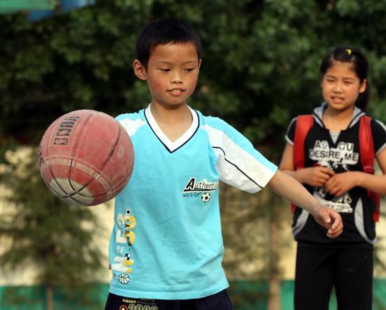 图文:四川绵阳籍小学生何建在打篮球