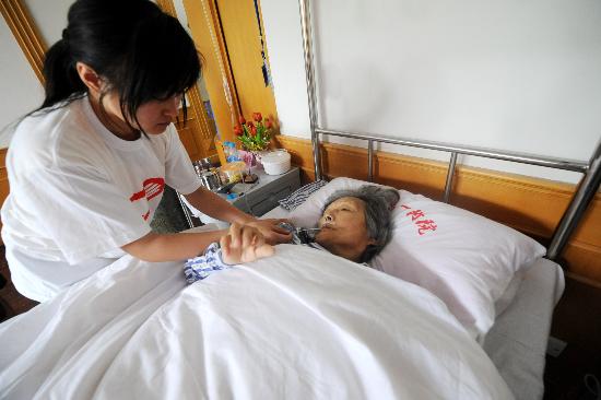 图文:志愿者在医院照顾受伤的75岁大妈杜素珍